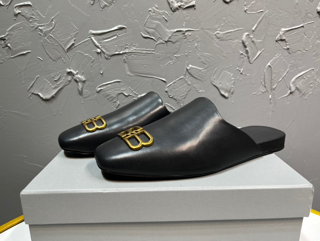 Black leather slide sandals with gold B-logo accents, open toe, low profile