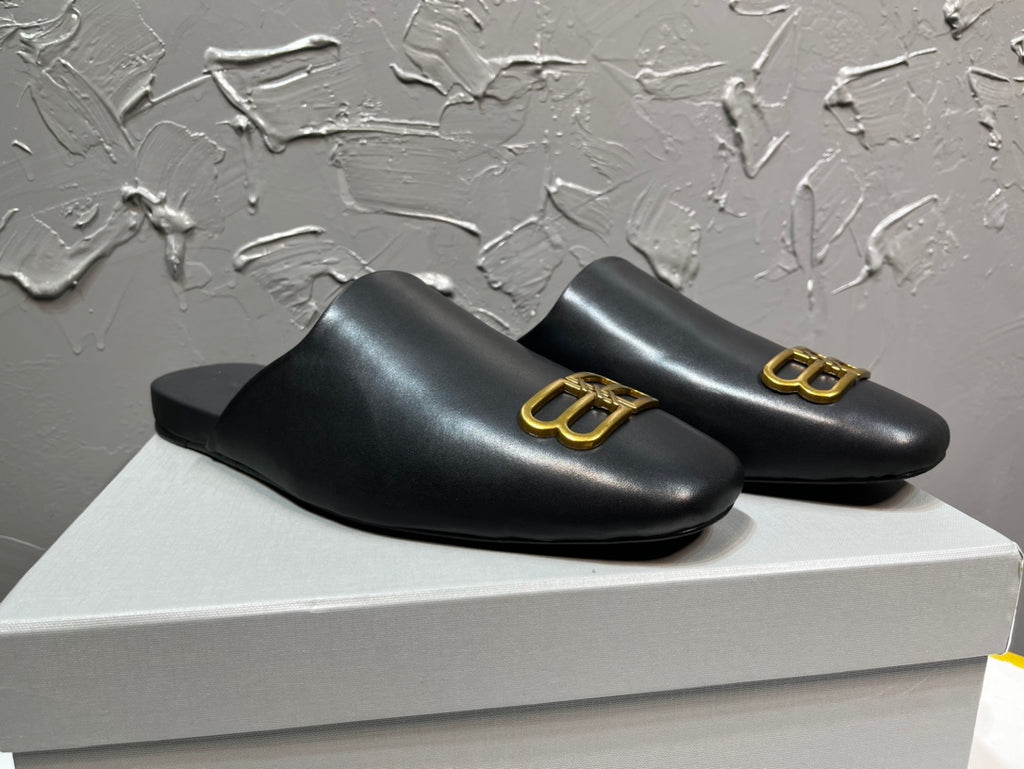 Black leather slide sandals with gold B-logo ornament on upper, curved vamp