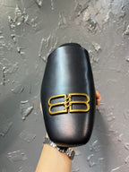Black leather slide sandal with gold B-logo on top, rear view
