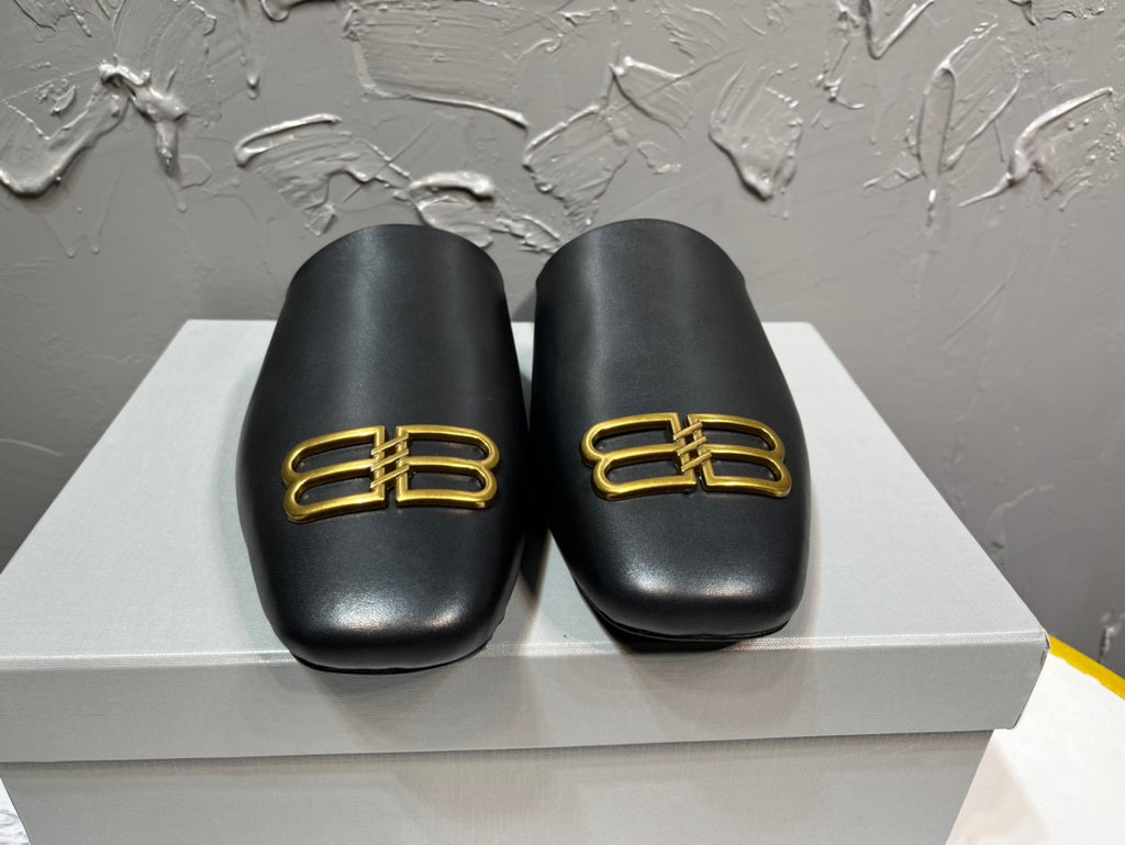 Black leather slide sandals with gold B-logo on front, cushioned footbed