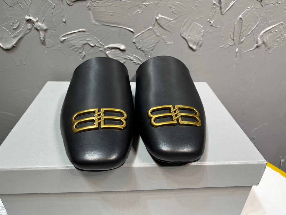 Black leather slide sandals with gold B-logo on front, cushioned footbed