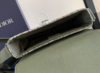Dior bag open with light interior lining and green leather exterior, top zipper edge.