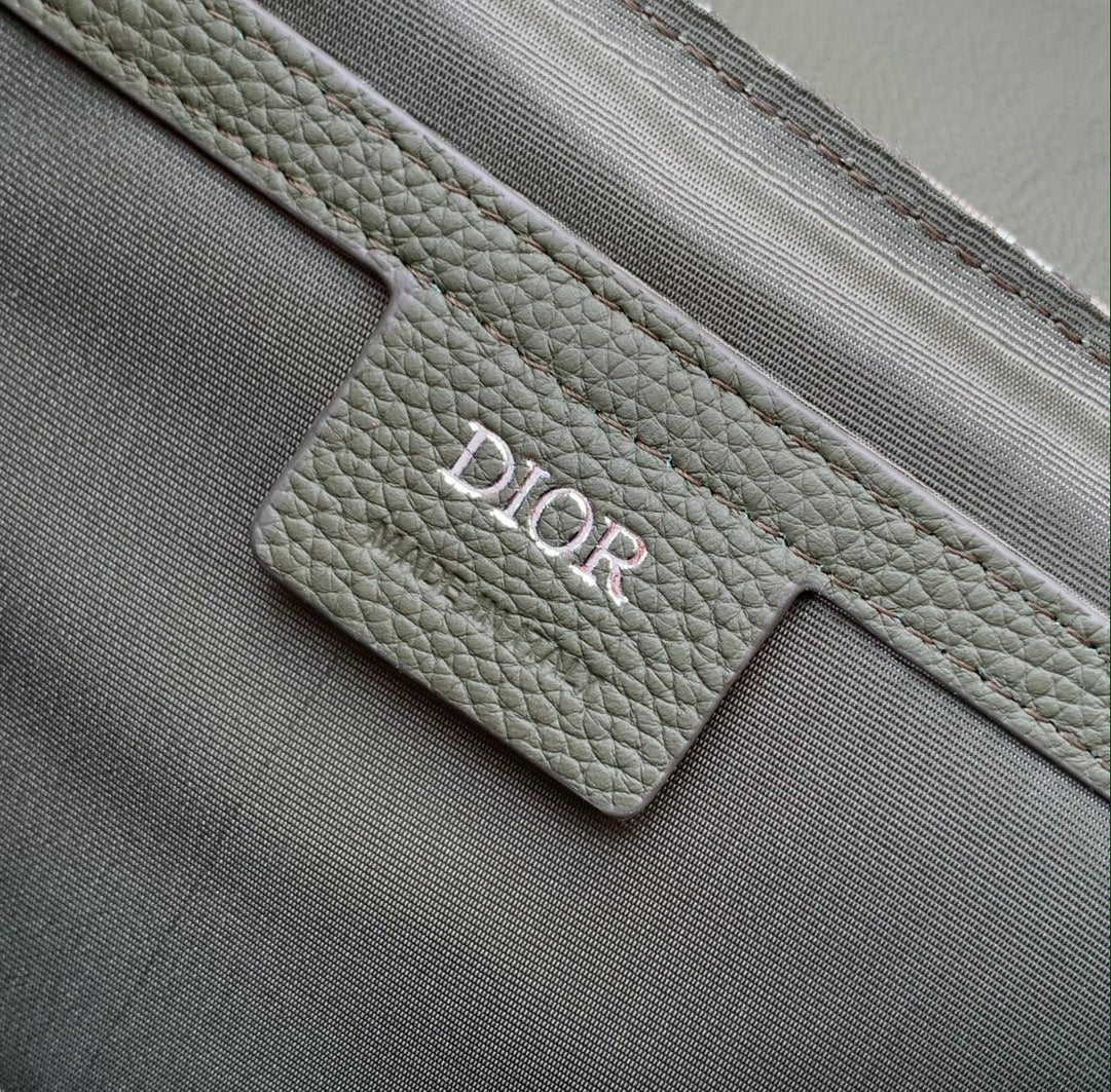 Olive green pebbled strap with embossed Dior logo tab on the bag