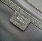 Dior bag close-up of green leather strap with stitched Dior logo panel.
