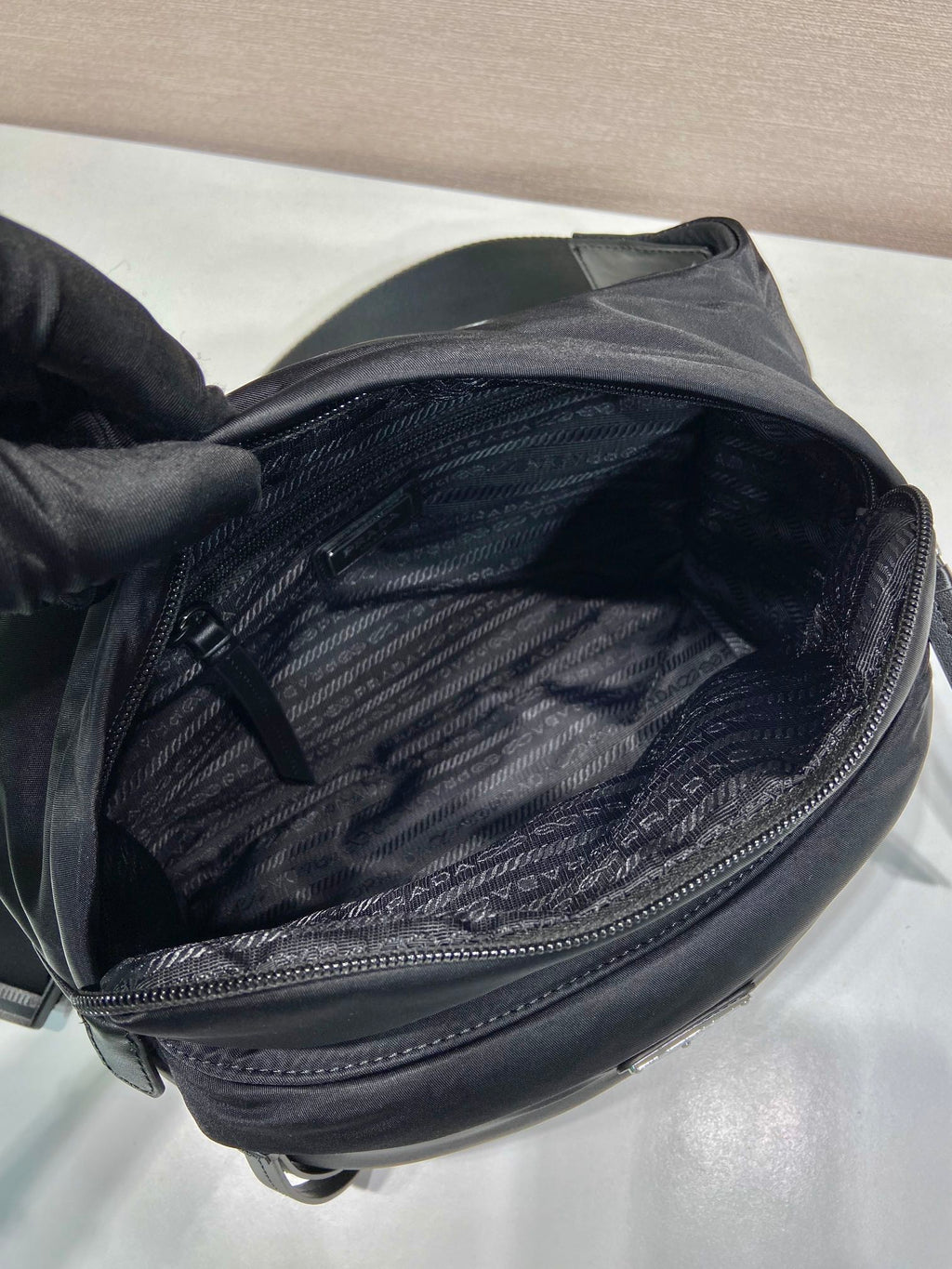 Prada black nylon bag interior view with zip pocket and textured lining
