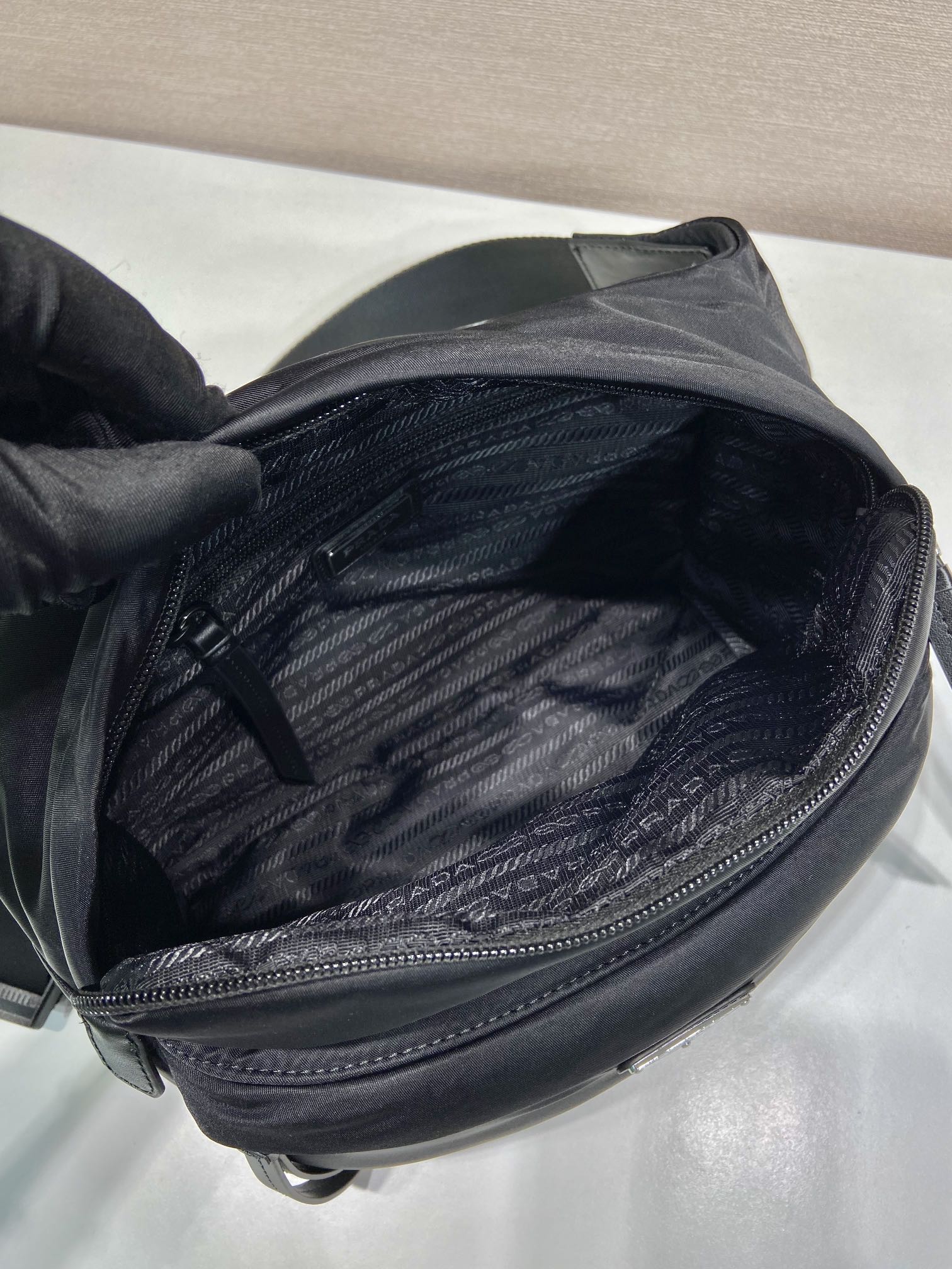 Prada black nylon bag interior view with zip pocket and textured lining