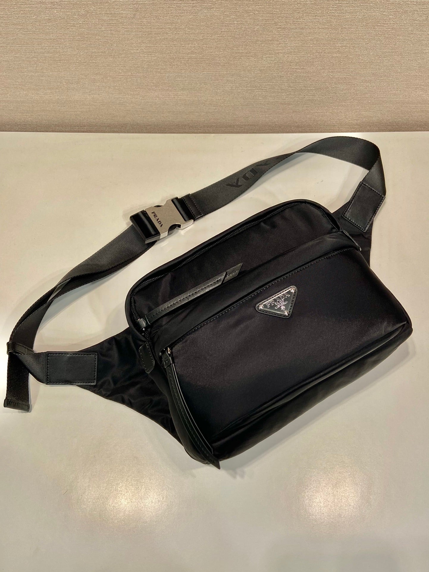 Prada black crossbody bag with front flap, silver zipper, and leather trim