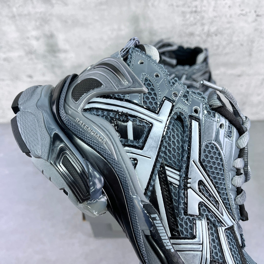 Sneaker quarter view with textured mesh, silver trim, and molded cushioned sole