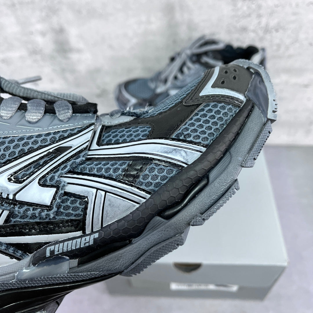 Sneaker side view with blue-gray mesh, silver trim, and chunky sole detail