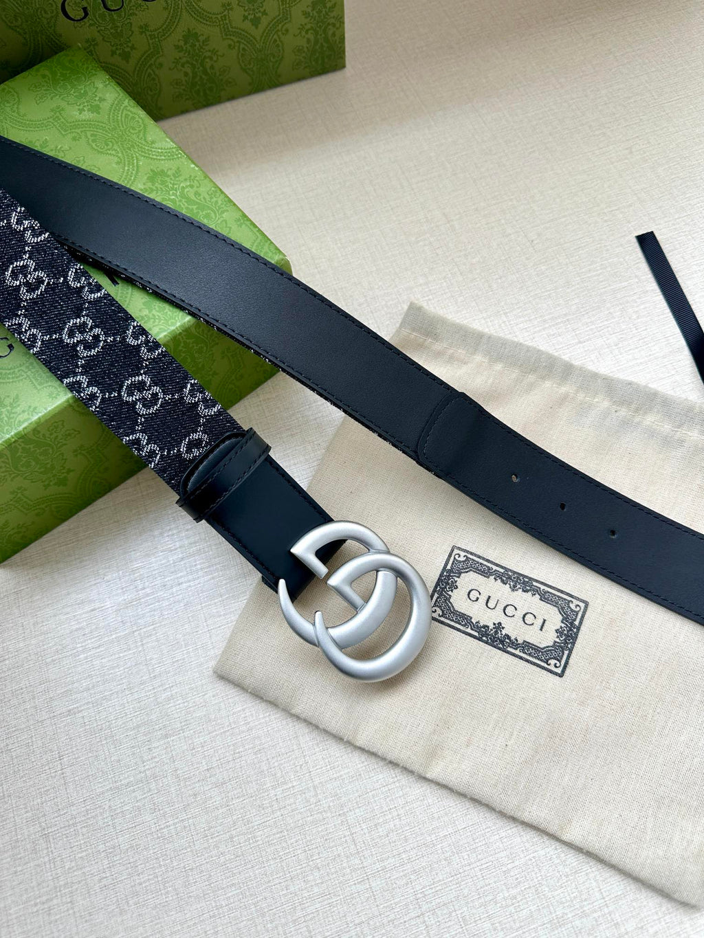 Gucci belt side view: silver double-G buckle on dark navy leather strap