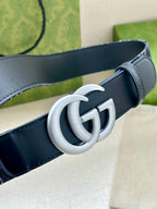 Gucci belt buckle closeup: silver double-G on dark navy leather strap