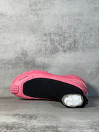Sock boot sneaker with pink shell, black sock opening, textured lug outsole.