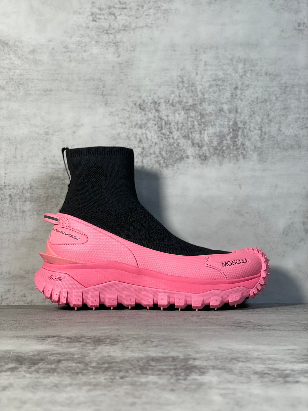 Moncler sock boot sneaker with black knit upper and pink lug sole, side logo.