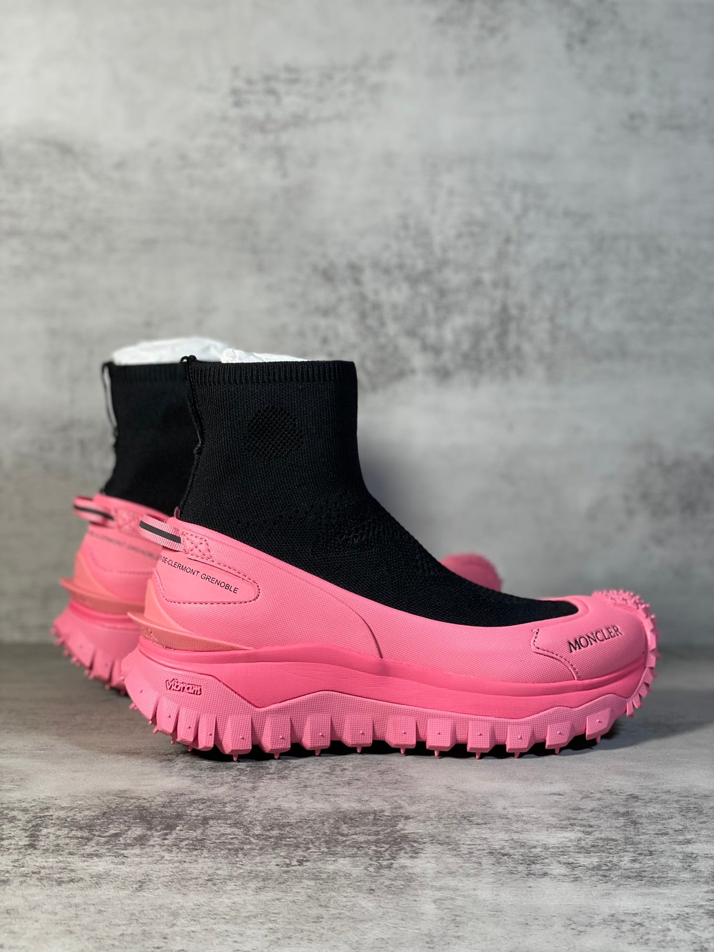 Sock boot sneaker with black knit ankle, pink midsole and chunky tread.