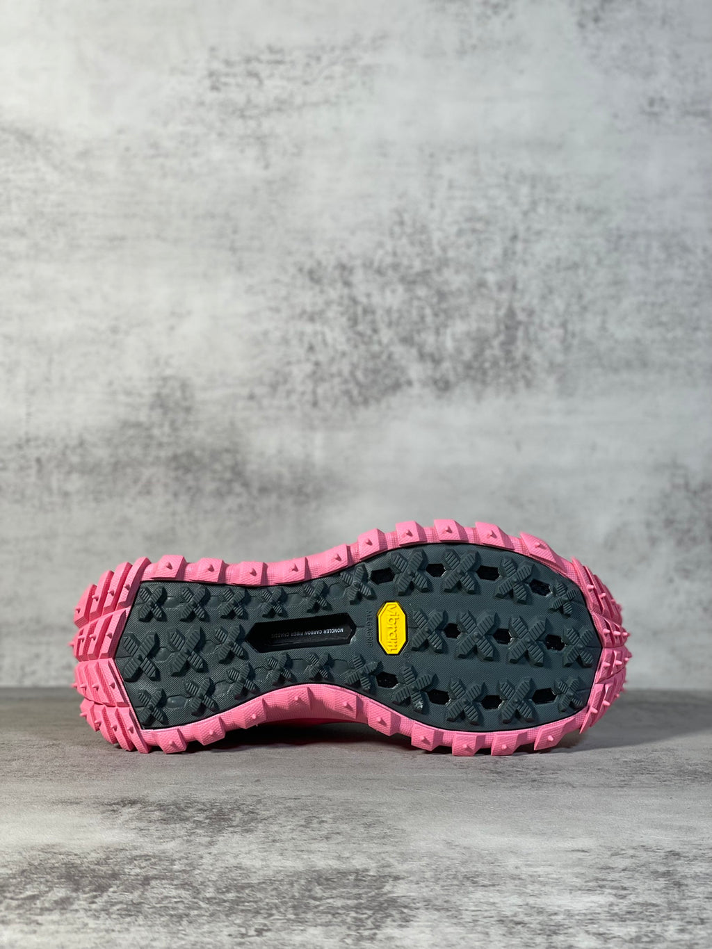 Rubber lug outsole in black with pink edge, rugged tread pattern for grip.