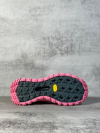 Rubber lug outsole in black with pink edge, rugged tread pattern for grip.