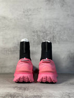Pair of sock boot sneakers: black knit heels with pink rear and lug tread soles.