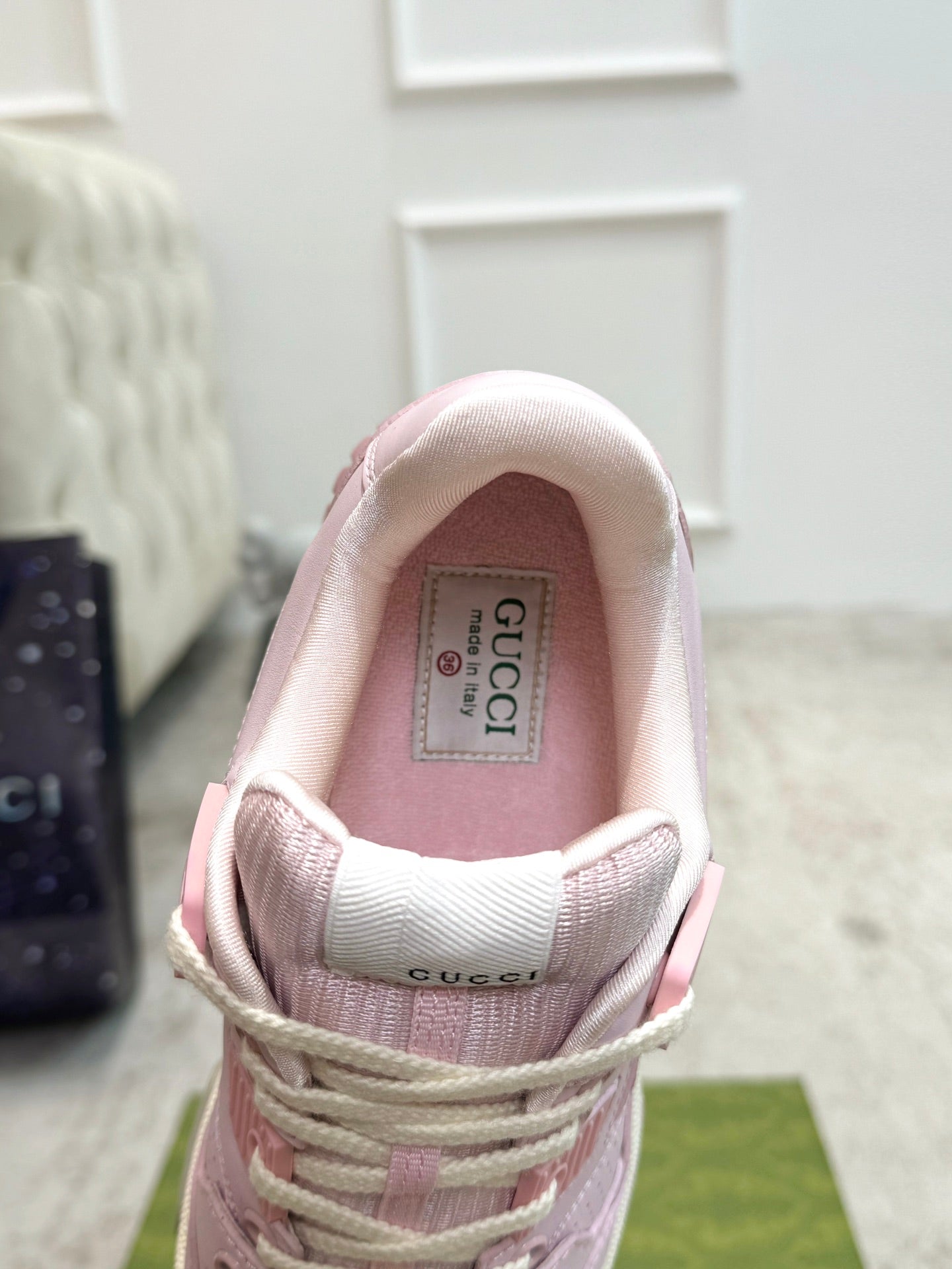 Pink Gucci sneakers inside view, showing padded collar and tongue label