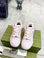 Pink Gucci lace-up sneakers on box, white laces and stitched toe perforations.