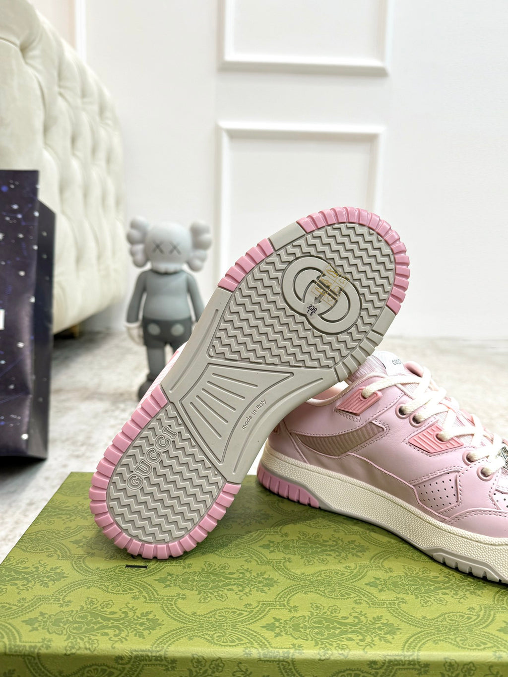 Pink Gucci sneaker outsole view with patterned tread and pink edge trim.
