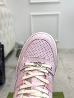 Pink Gucci sneaker toe close-up with perforated leather and lace hardware.