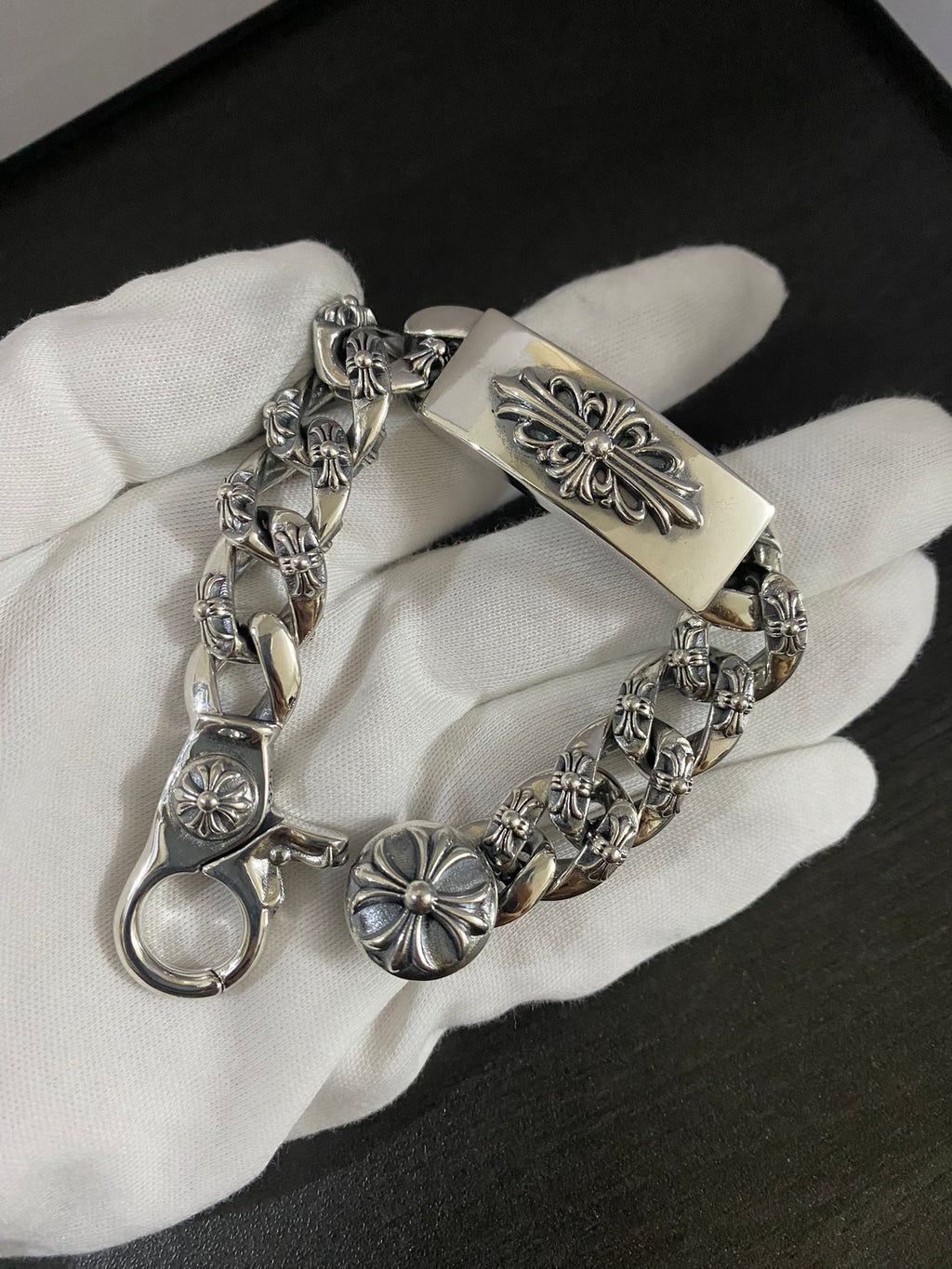 Fleur-de-lis charm bracelet with engraved center bar on white glove
