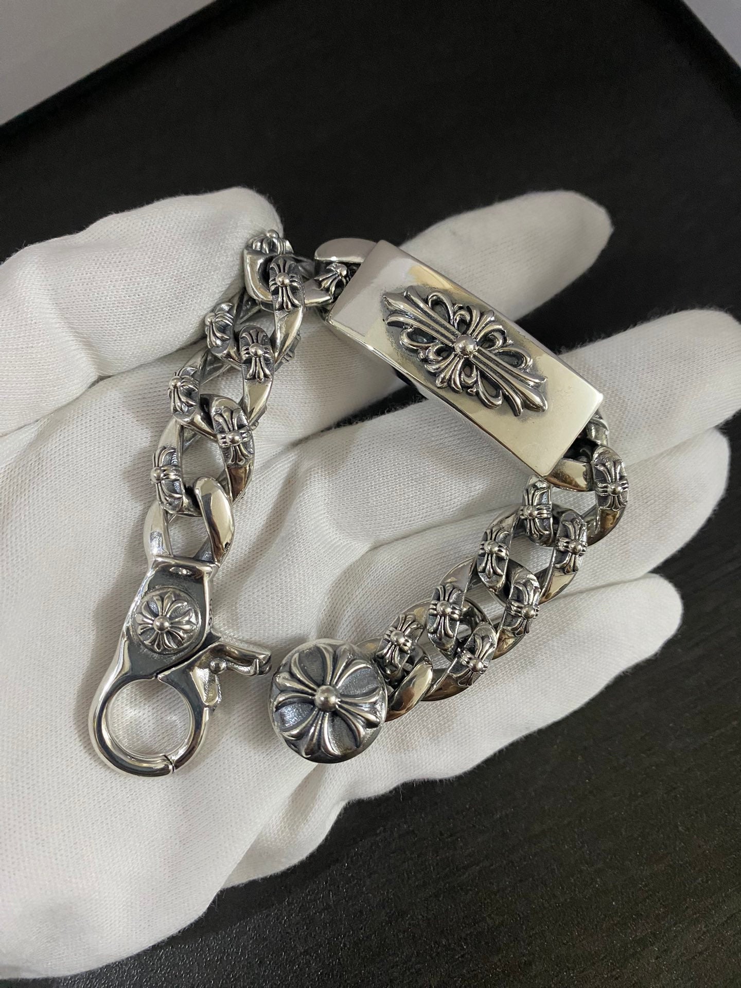 Fleur-de-lis charm bracelet with engraved center bar on white glove