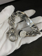 Chrome accessories charm bracelet with oval clasp and engraved links on white glove