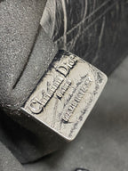 Dior embossed logo on dark metallic leather corner, stitch detail