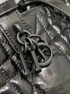 Dior bag hardware close-up: interlocking dark metal 'D I O R' charm on leather