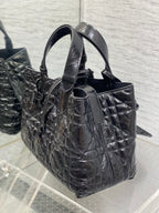 Dior tote bag side view with top handles, structured sides, quilted black leather