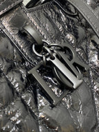 Dior tote bag corner close-up with black hardware and textured metallic leather