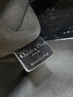 Dior logo leather label tag, embossed text on black bag lining