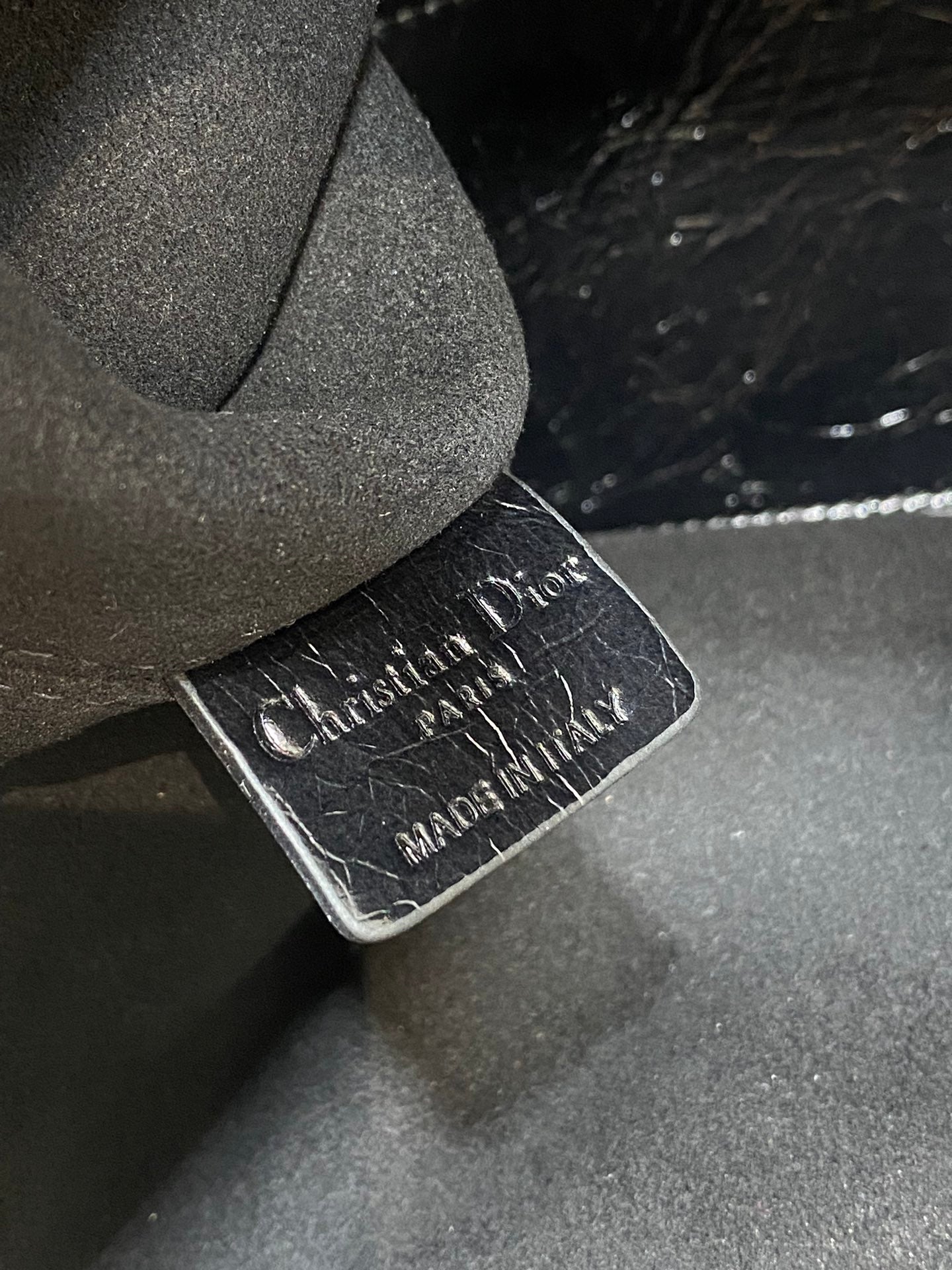 Dior logo leather label tag, embossed text on black bag lining