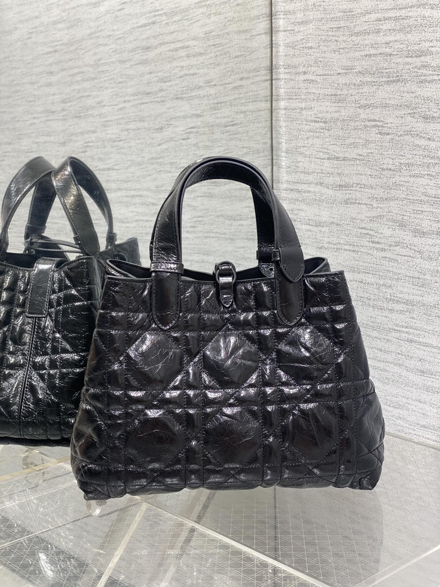 Dior tote bag front view with ring clasp, quilted texture and top handles, black