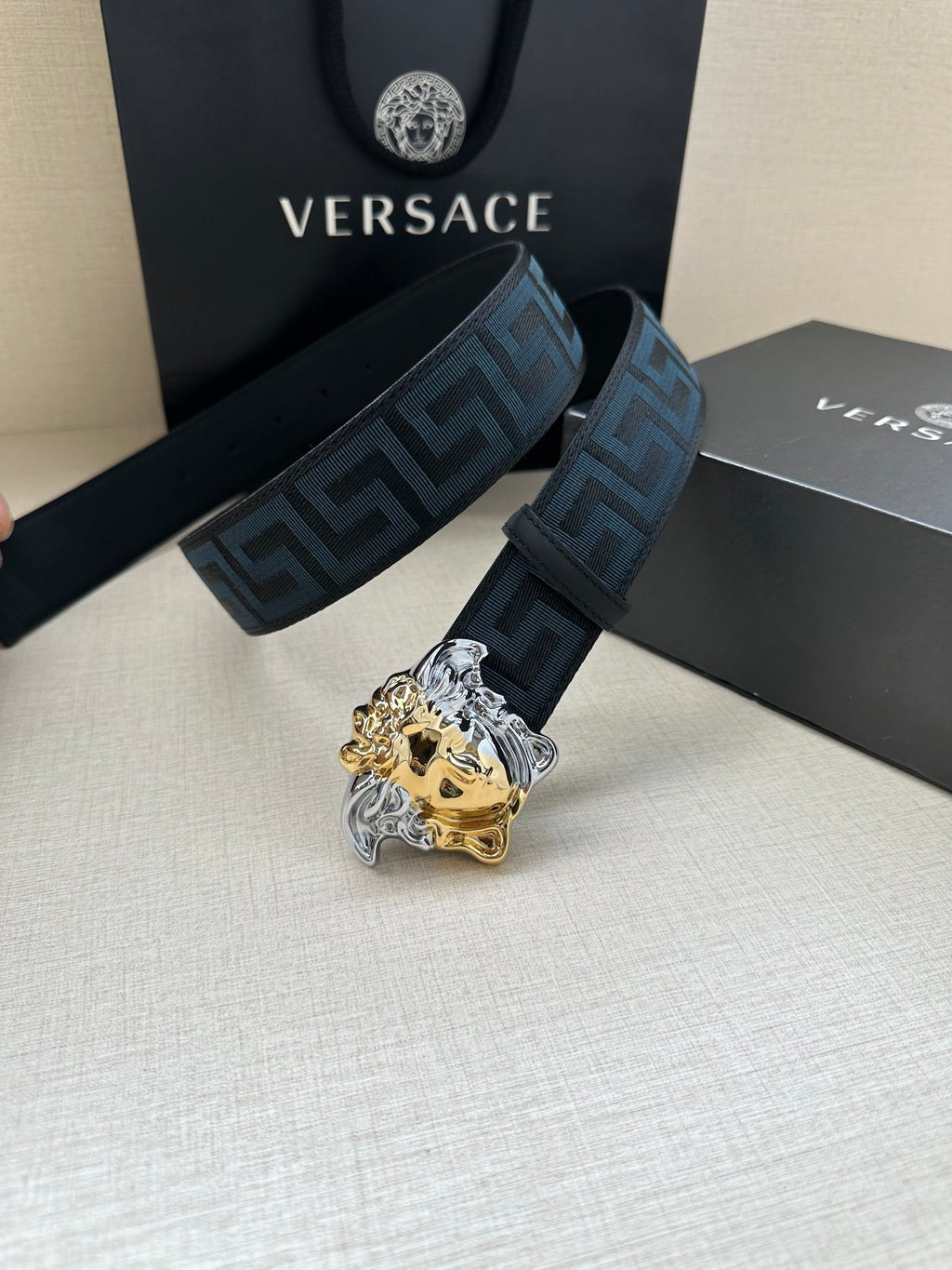 Versace belt: blue Greek-key strap and gold/silver Medusa head buckle, side view.
