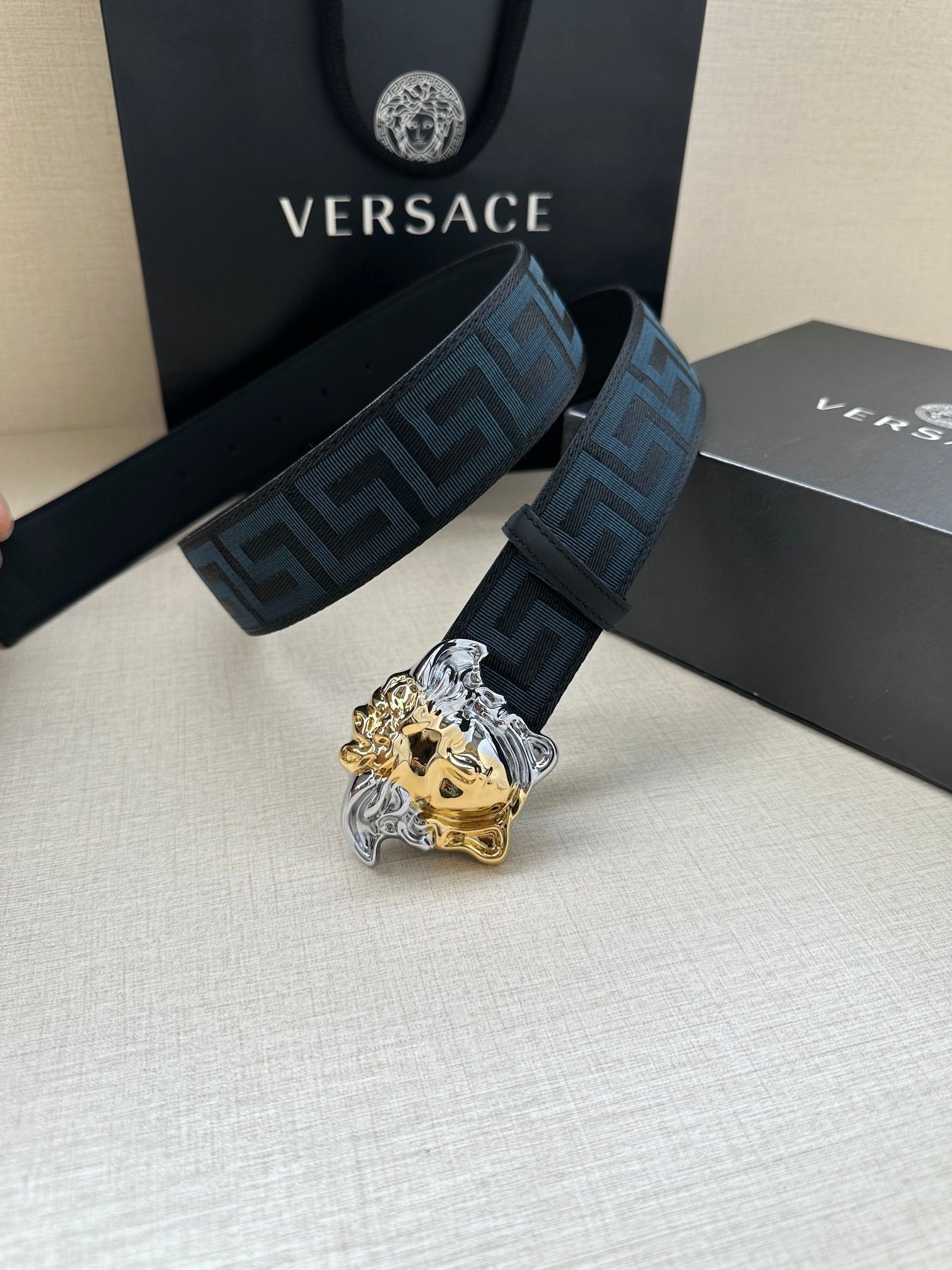 Versace belt: blue Greek-key strap and gold/silver Medusa head buckle, side view.