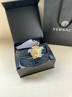 Versace belt in open box: blue Greek-key strap with gold/silver Medusa buckle.