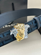 Versace belt close-up: blue Greek-key strap with gold and silver Medusa buckle.
