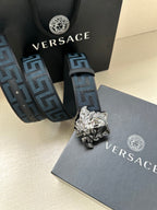 Versace belt with blue Greca-style pattern strap and large silver Medusa buckle.