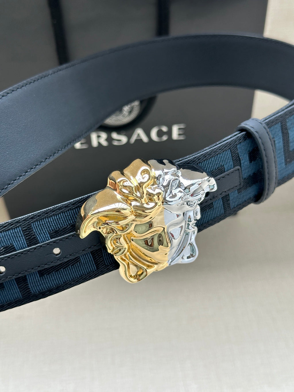 Dark blue patterned belt with Greca motif and ornate gold-silver Medusa buckle
