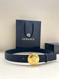 Navy leather belt with round gold medallion buckle and belt holes