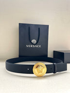 Navy leather belt with round gold medallion buckle and belt holes