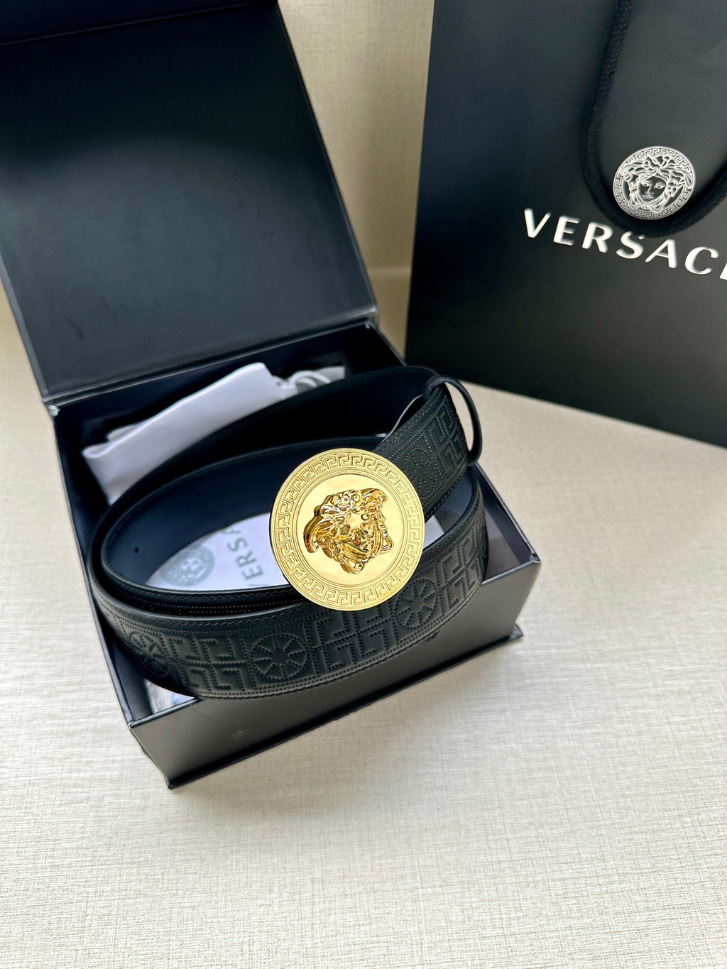 Versace belt in dark blue leather with gold Medusa medallion buckle.