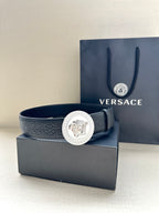 Versace belt in dark blue leather with silver Medusa medallion buckle at center.