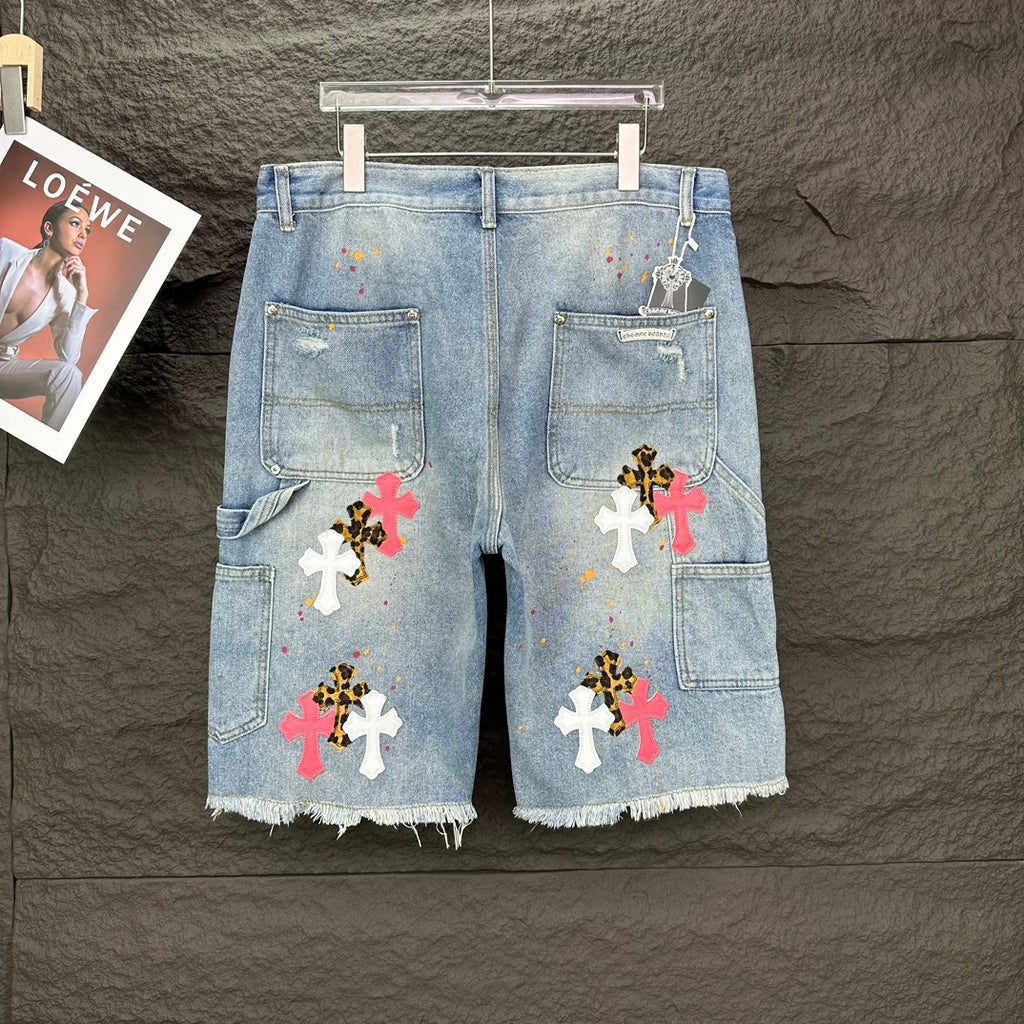 Light blue denim shorts, full front view, with colorful cross patches and frayed edges