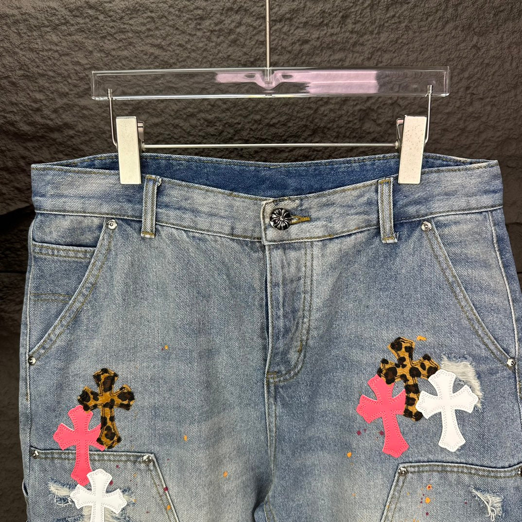 Light blue denim shorts, front view, with colorful cross patches on legs