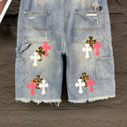 Light blue denim shorts front view with cross appliqués and cargo-style pockets