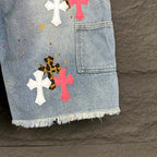Light blue denim shorts pocket with cross patches in white, pink, and black