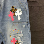 Light blue denim shorts close-up of pocket with cross appliqués and distressing